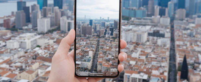 hand-taking-photo-over-city